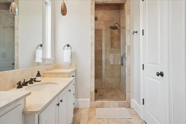 a bathroom with a shower sink and mirror