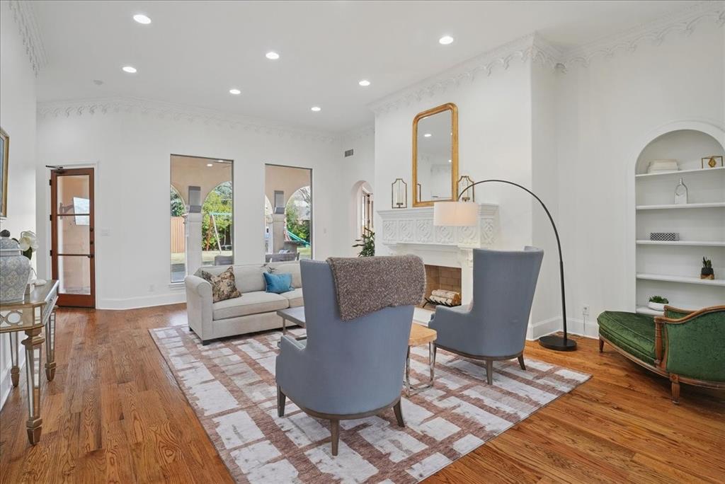 6807 Lupton Drive Dallas, TX 75225 - Photo 6 of 40 a living room with furniture a wooden floor and a fireplace