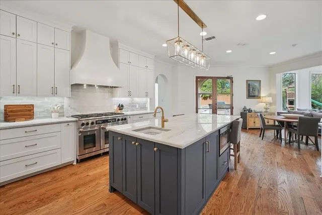 a kitchen with granite countertop a sink cabinets and wooden floor