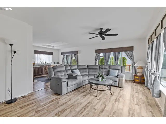 a living room with furniture and a large window with wooden floor