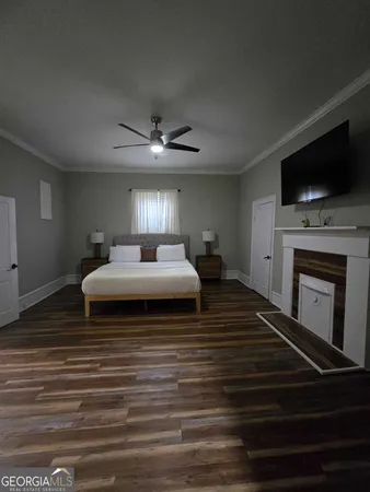 a bedroom with a bed a flat screen tv and a fireplace