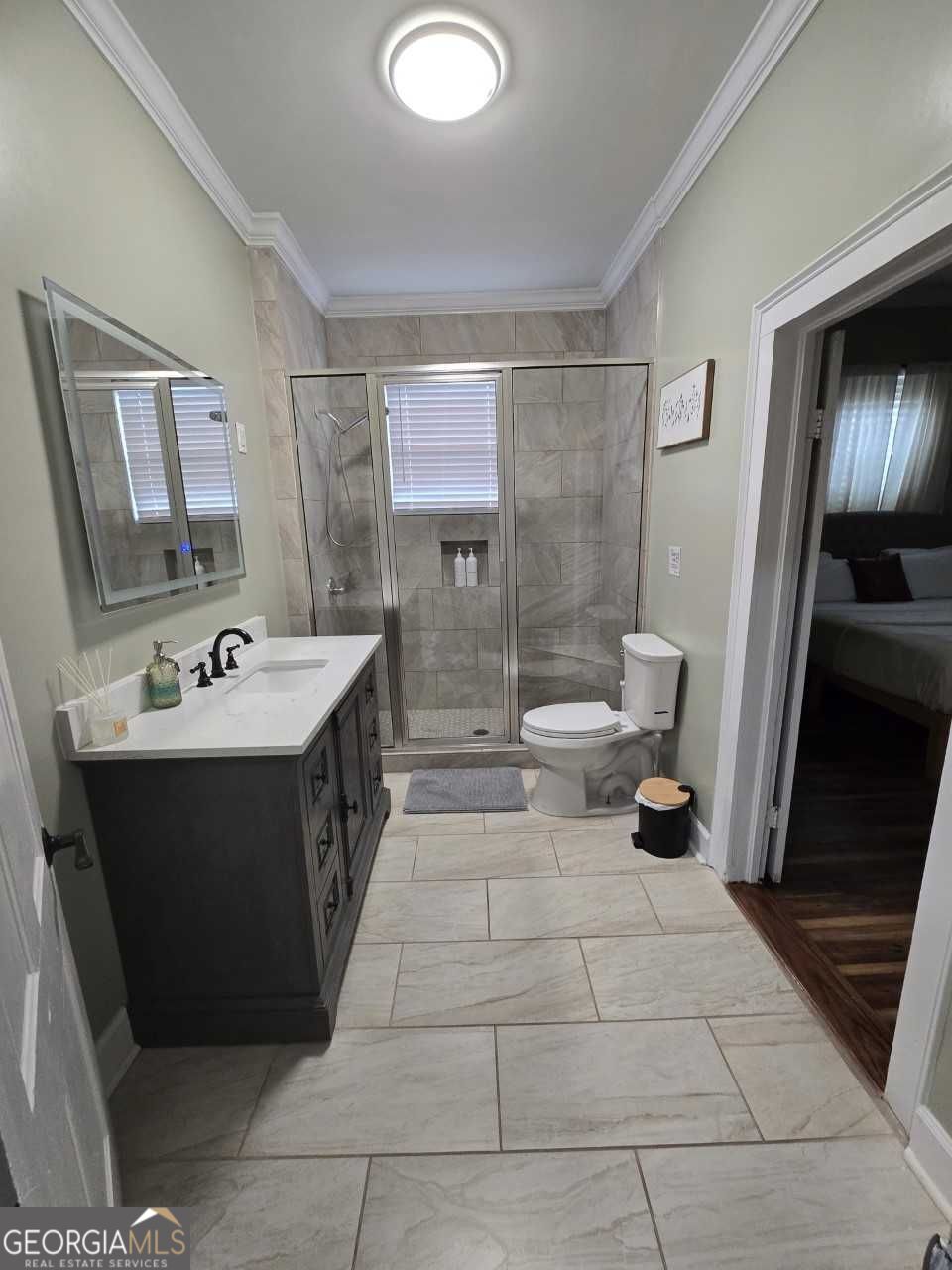 402 Meriwether Street Griffin, GA 30224 - Photo 12 of 38 a bathroom with a double vanity sink a mirror and a shower