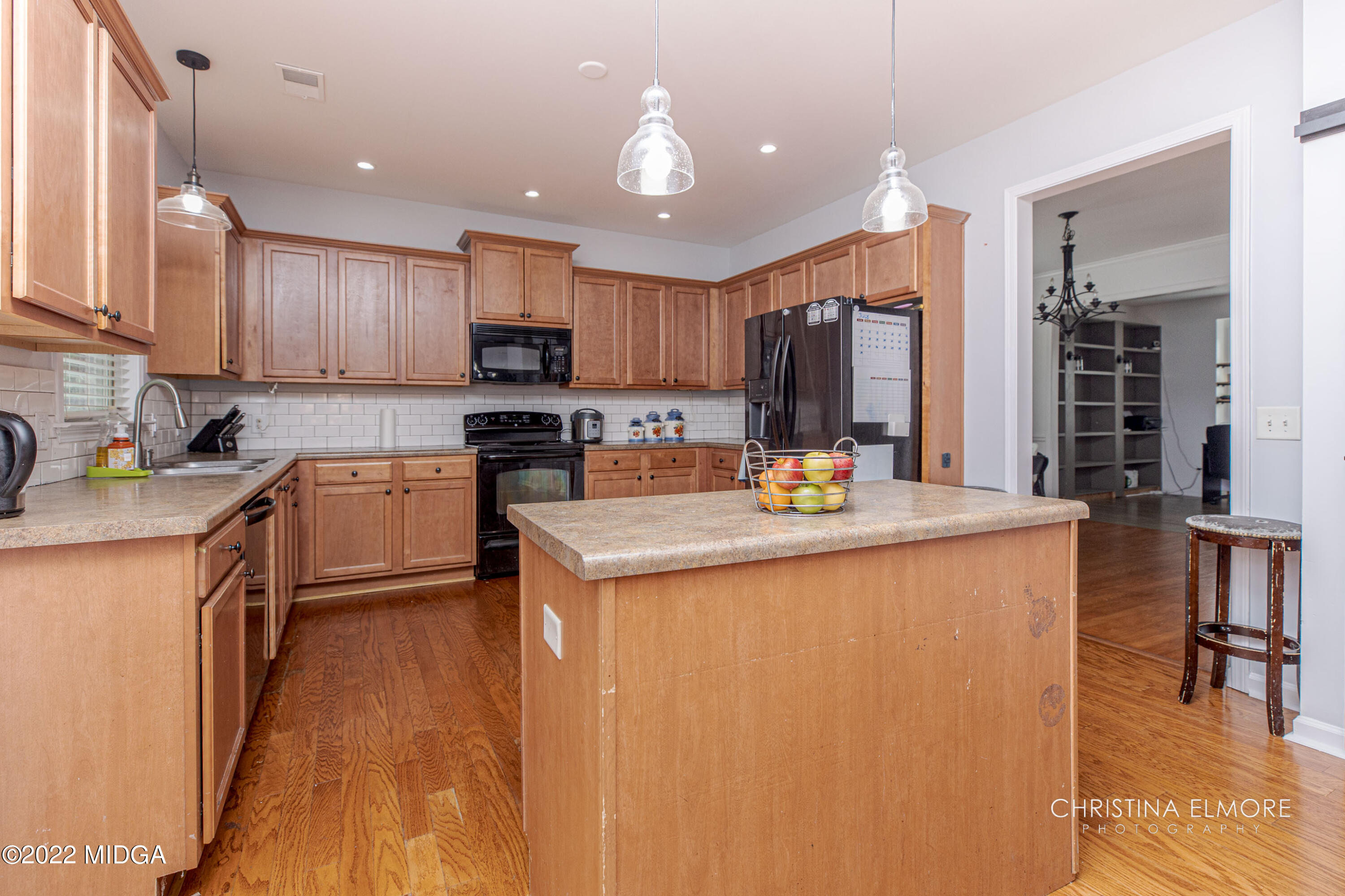 209 McEwen Court Perry, GA 31069 - Photo 12 of 39 a kitchen with kitchen island granite countertop wooden cabinets and a refrigerator