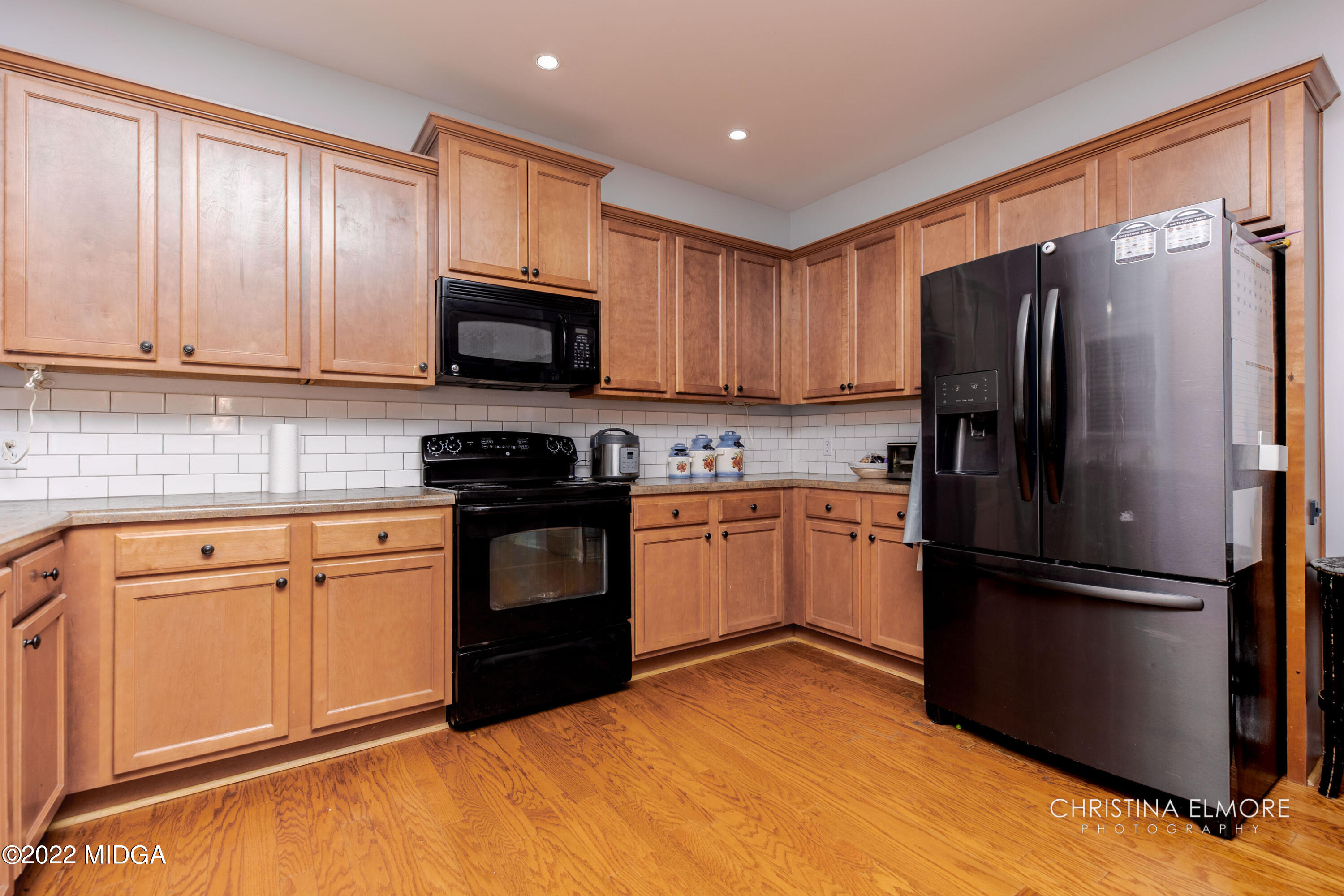 209 McEwen Court Perry, GA 31069 - Photo 14 of 39 a kitchen with granite countertop wooden cabinets a refrigerator stove top oven and sink