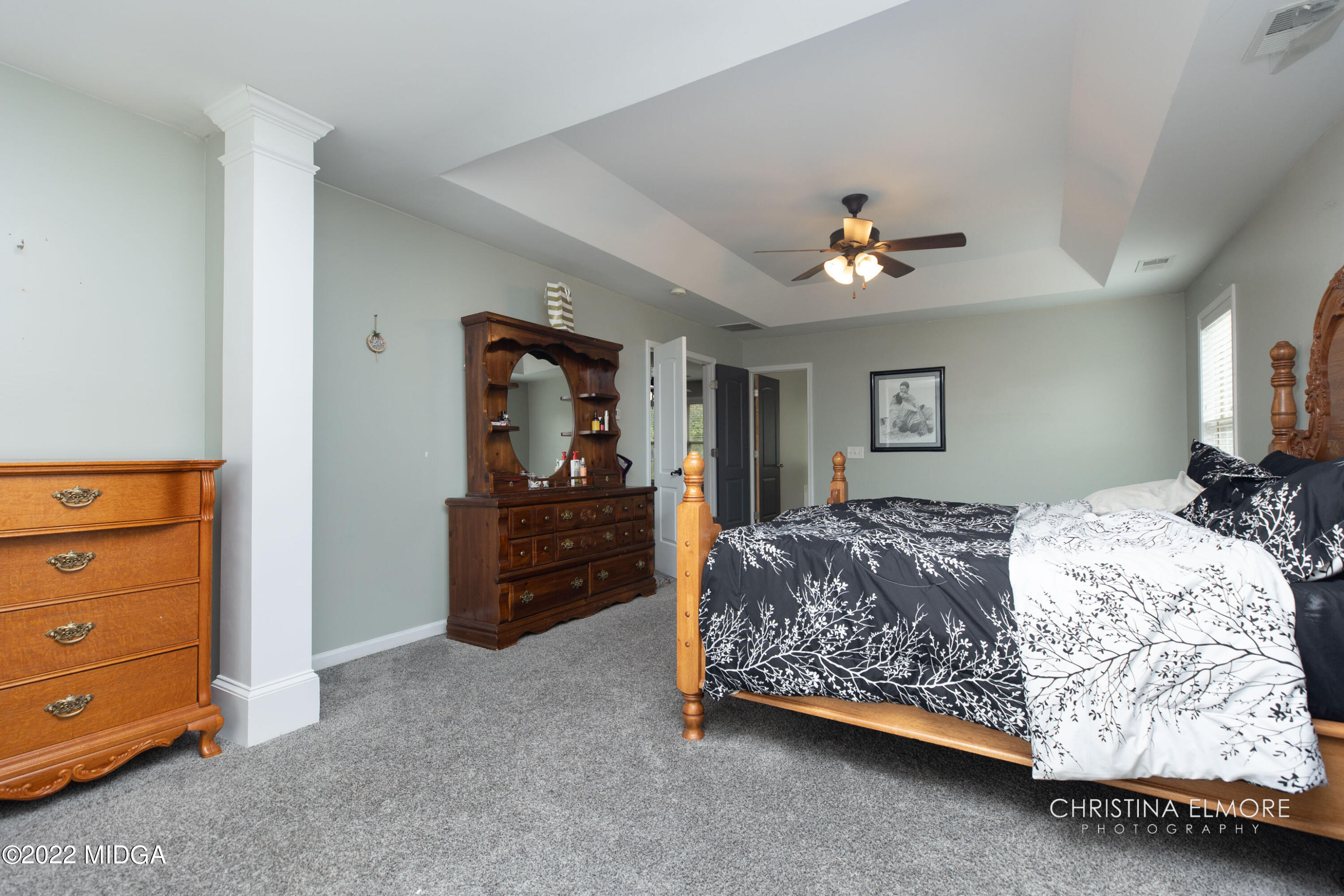 209 McEwen Court Perry, GA 31069 - Photo 26 of 39 a spacious bedroom with a bed and a dresser in it
