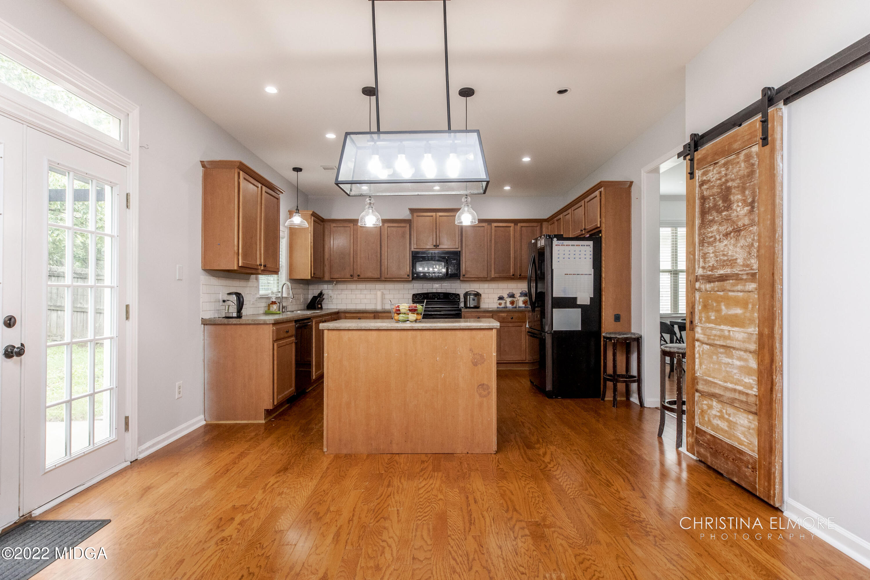 209 McEwen Court Perry, GA 31069 - Photo 10 of 39 a kitchen with stainless steel appliances kitchen island granite countertop a stove top oven a refrigerator a sink and a cabinets with wooden floor