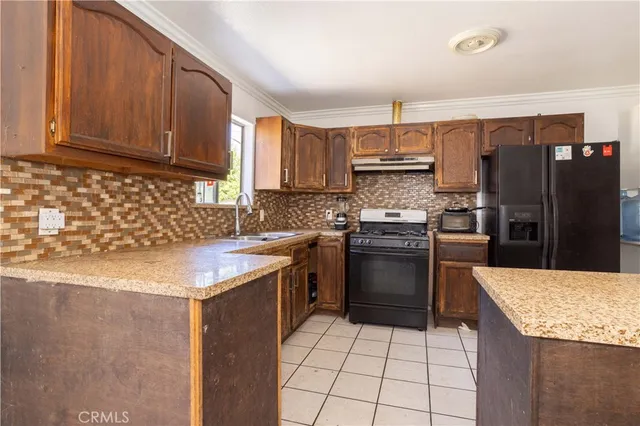 a kitchen with a sink a stove top oven and refrigerator
