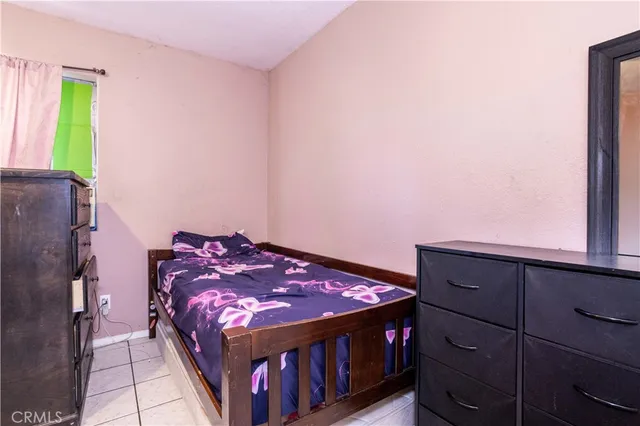 a bed sitting in a bedroom next to a window