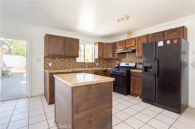 a kitchen with stainless steel appliances granite countertop a refrigerator stove and sink