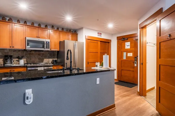 a kitchen with stainless steel appliances a refrigerator a stove a sink cabinets and a dining table