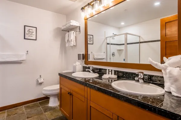 a bathroom with a granite countertop sink a toilet and a mirror