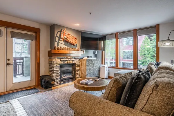 a living room with furniture a fireplace and a large window