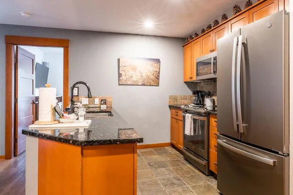 a kitchen with stainless steel appliances granite countertop a sink stove and refrigerator