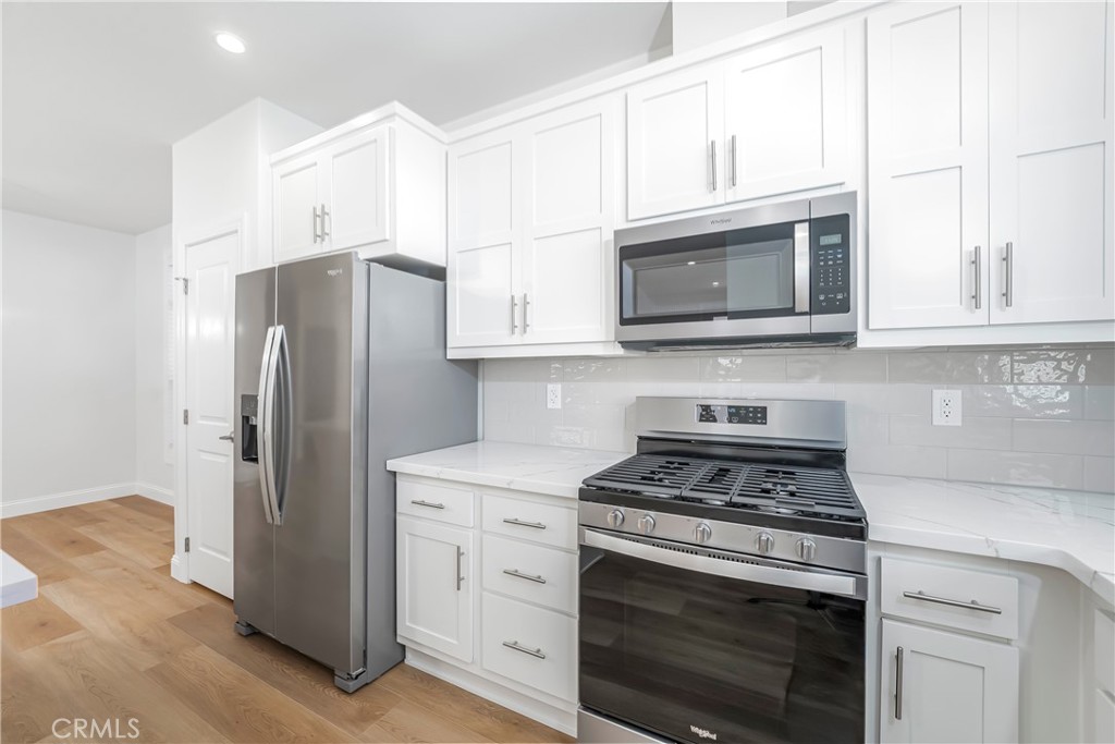 14851 Jeffrey Road, Unit 145 Irvine, CA 92618 - Photo 14 of 32 a kitchen with stainless steel appliances white cabinets white stove a microwave and a refrigerator