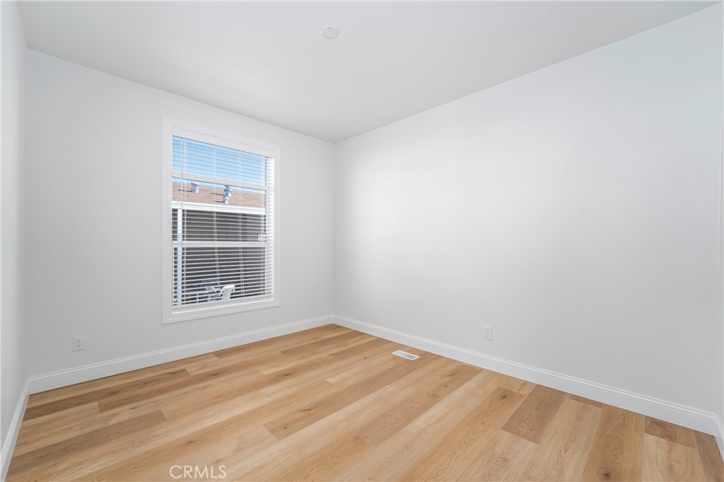 14851 Jeffrey Road, Unit 145 Irvine, CA 92618 - Photo 15 of 32 a view of empty room with wooden floor and fan
