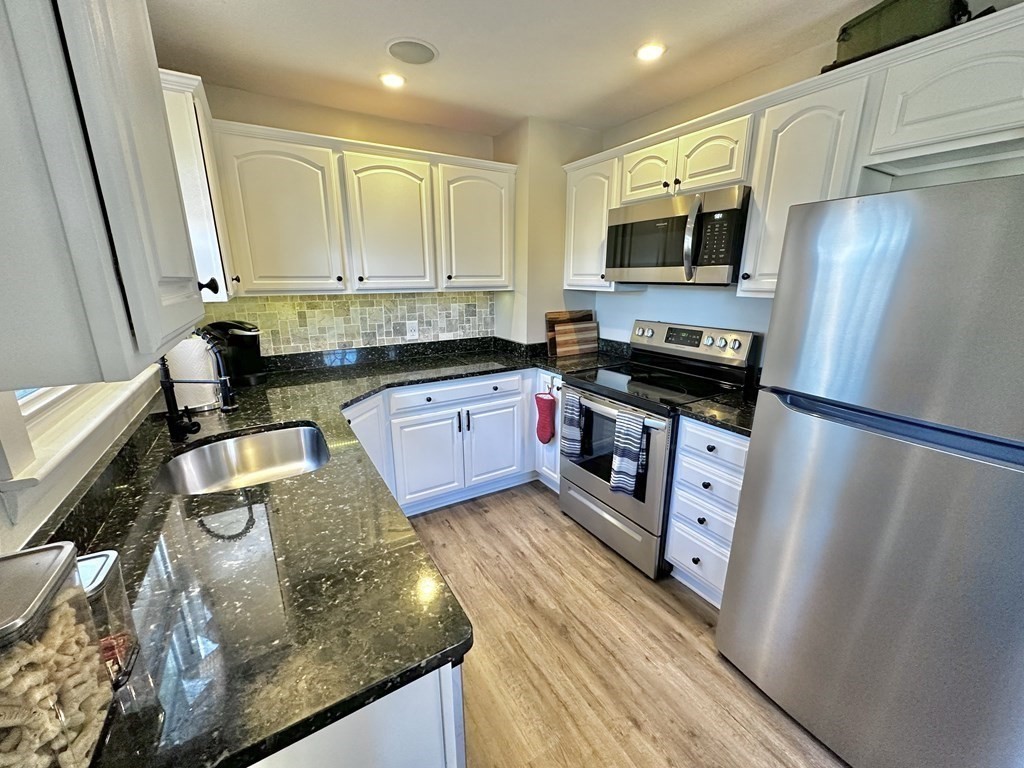 75 Coburn Road Berlin, MA 01503 - Photo 14 of 39 a kitchen with stainless steel appliances granite countertop a refrigerator a stove top oven a sink and dishwasher