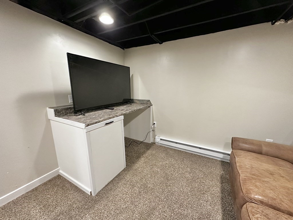 75 Coburn Road Berlin, MA 01503 - Photo 35 of 39 a living room with a flat screen tv on wall and a rug