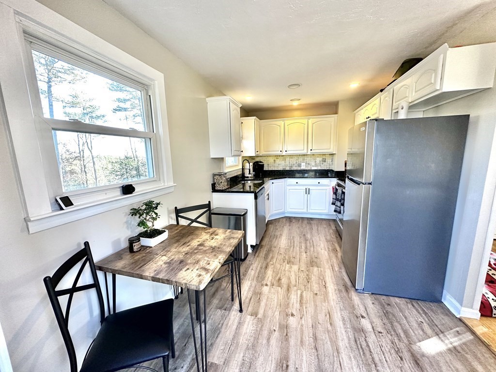 75 Coburn Road Berlin, MA 01503 - Photo 9 of 39 a kitchen with stainless steel appliances granite countertop a refrigerator sink and wooden floor