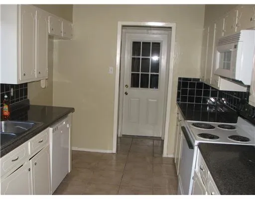 a kitchen with granite countertop a stove and a sink
