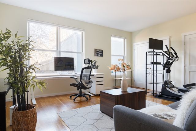 a view of a livingroom with workspace and a window