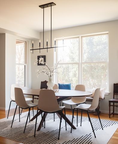 a dining room with furniture a chandelier and wooden floor