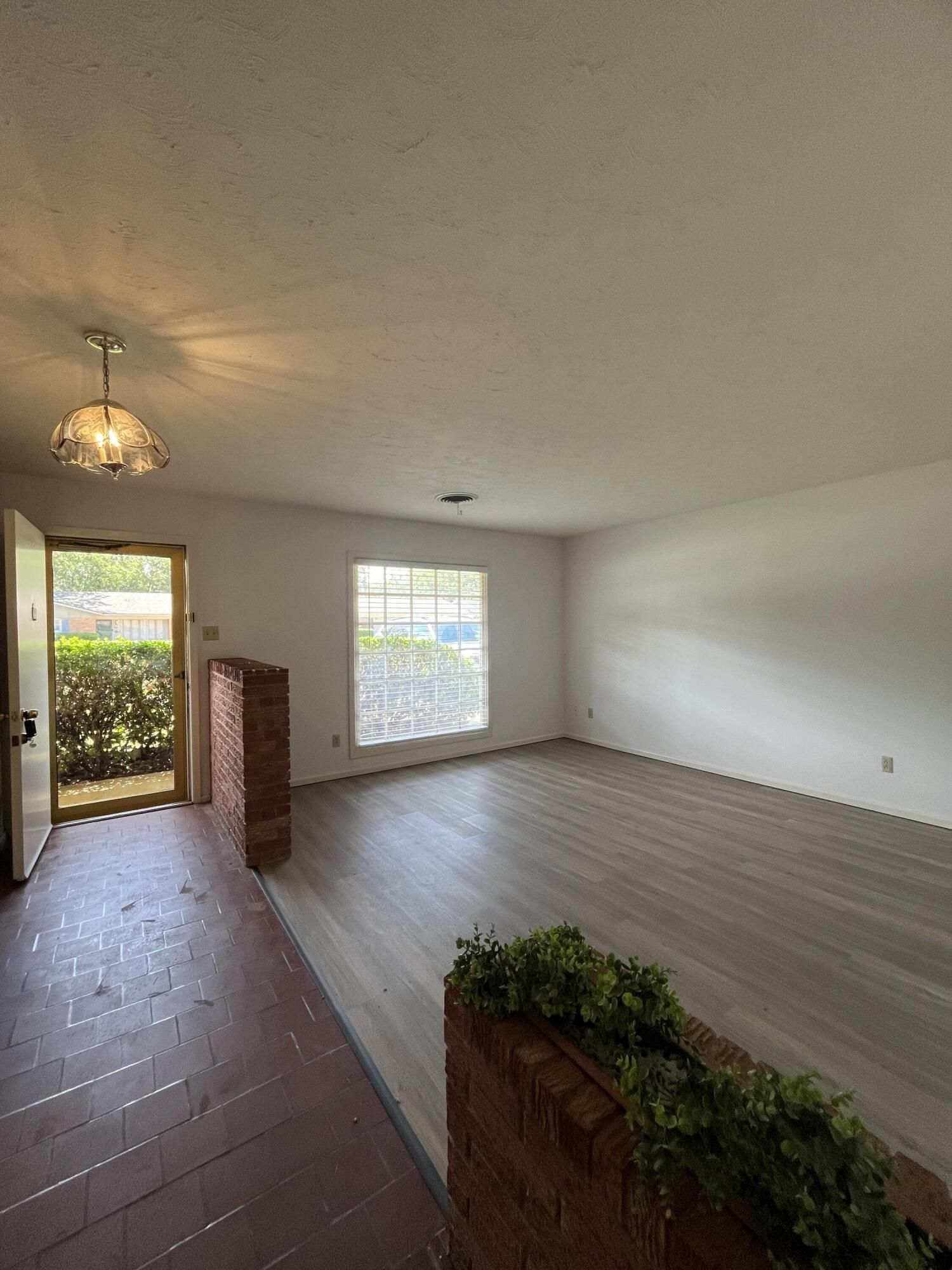 3614 56th Street Lubbock, TX 79413 - Photo 3 of 30 wooden floor in an empty room with a window