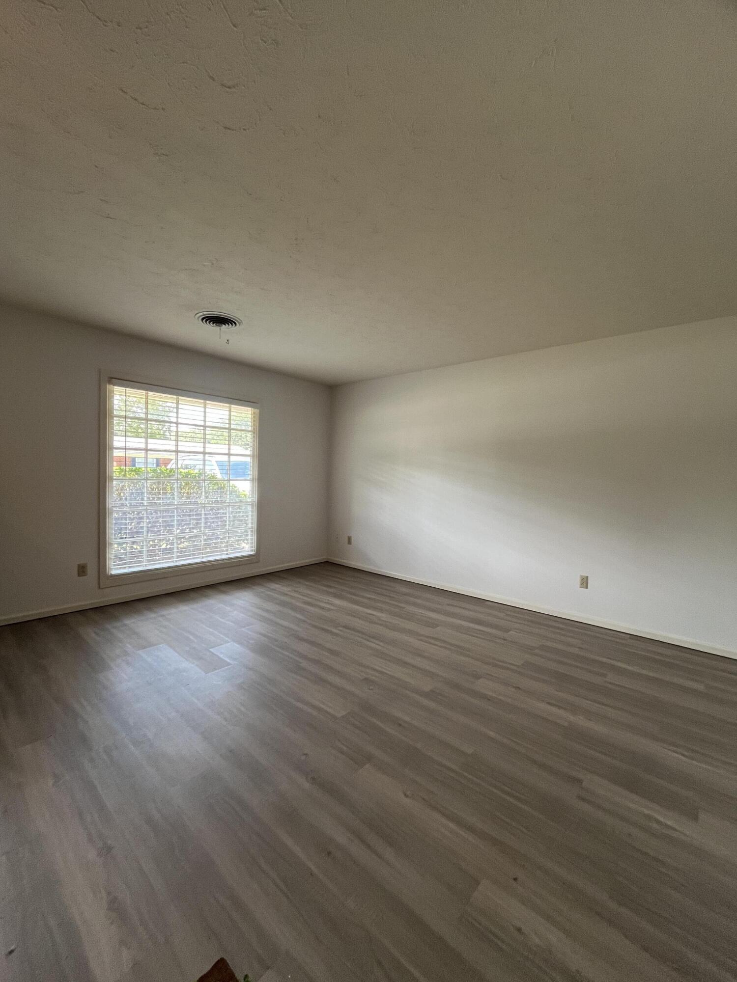 3614 56th Street Lubbock, TX 79413 - Photo 4 of 30 an empty room with wooden floor and windows
