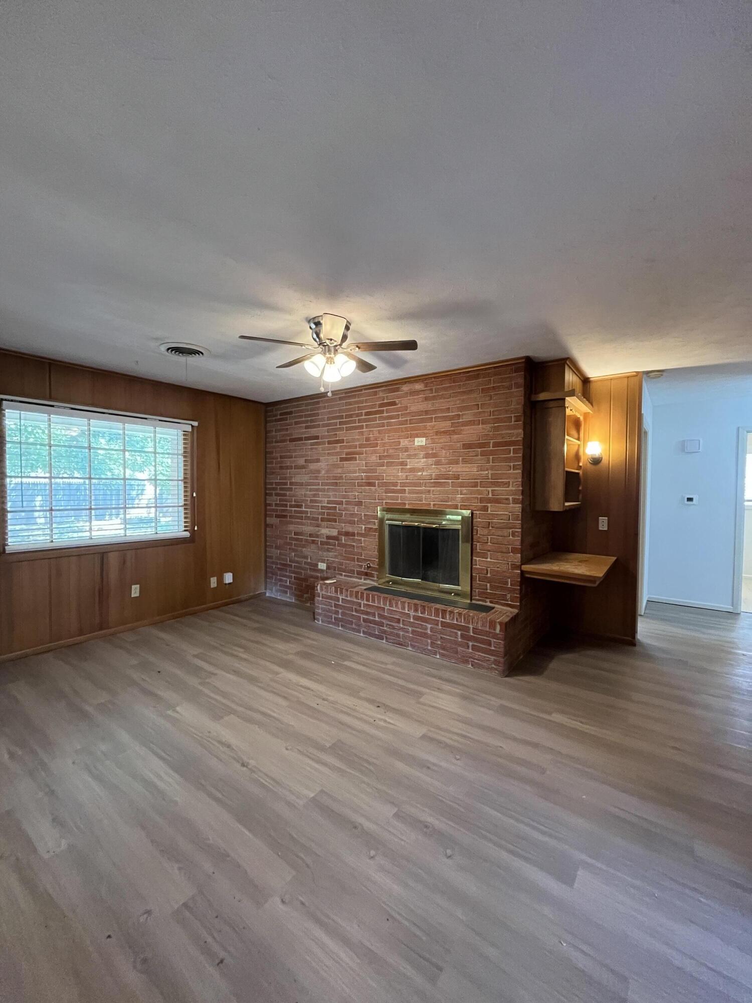 3614 56th Street Lubbock, TX 79413 - Photo 6 of 30 a view of an empty room with a fireplace and a window