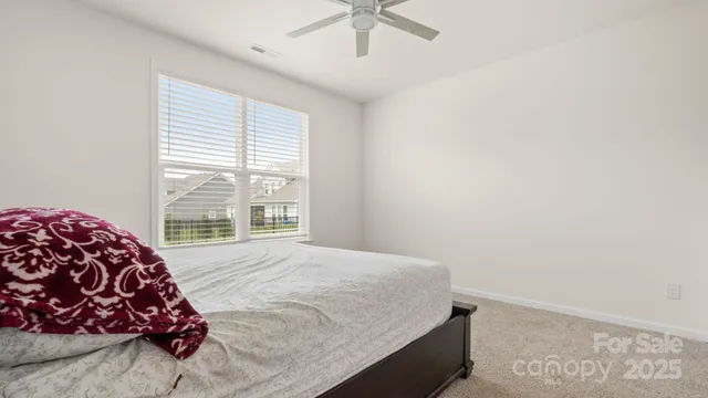 a bed sitting in a bedroom next to a window