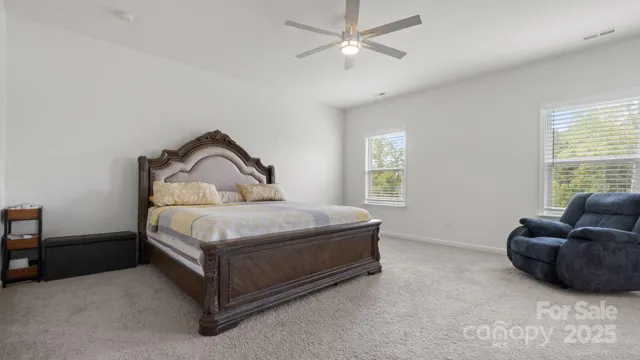 a bedroom with bed couch and window