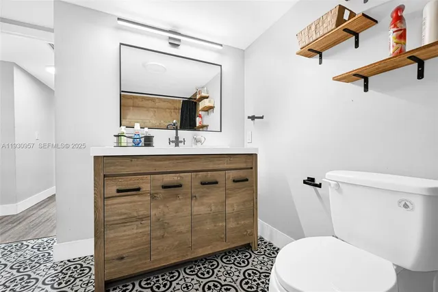 a bathroom with a sink a toilet a mirror and shower