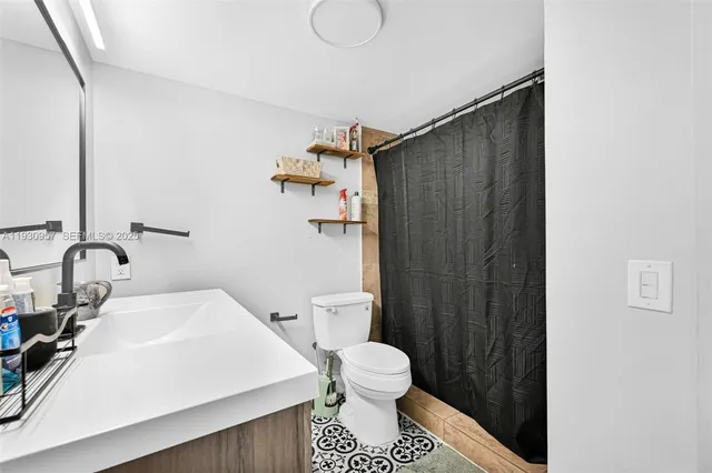 a bathroom with a sink toilet and shower