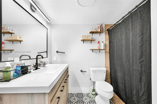 a bathroom with a sink a toilet and shower curtain