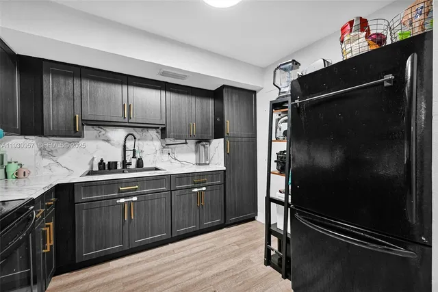 a kitchen with stainless steel appliances granite countertop a refrigerator and a sink