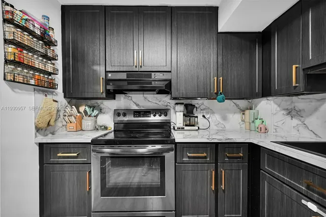 a kitchen with stainless steel appliances granite countertop wooden cabinets and a stove top oven