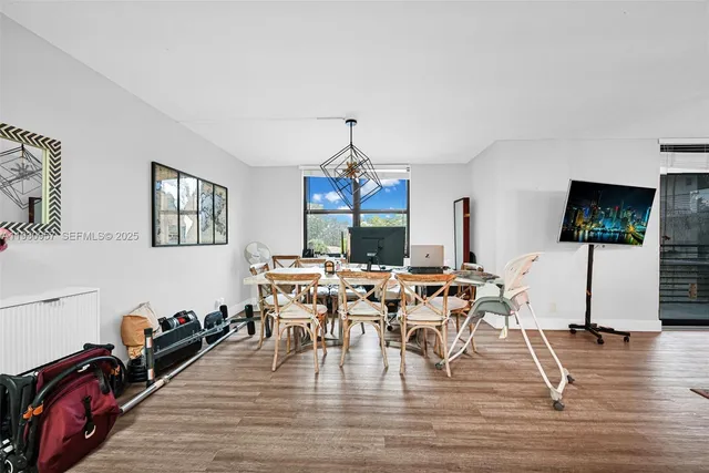 a living room with furniture a flat screen tv and a floor to ceiling window