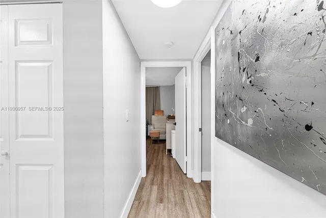 a view of a hallway with wooden floor and staircase