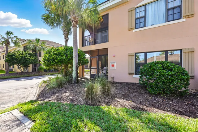 a view of a brick house next to a yard with potted plants