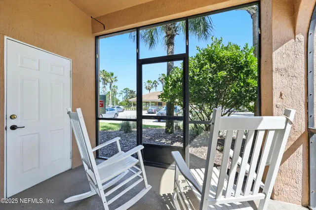 a view of a balcony with chairs and wooden floor