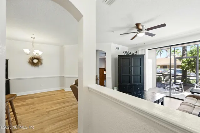 a bedroom with a bed ceiling fan and a large window