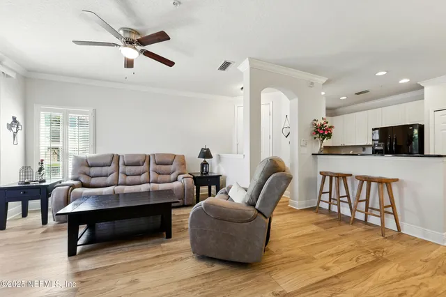 a living room with furniture and a wooden floor