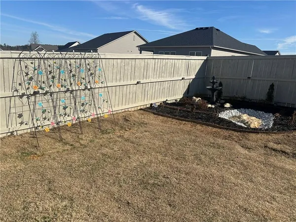 an empty room with wooden floor chandelier fan and windows