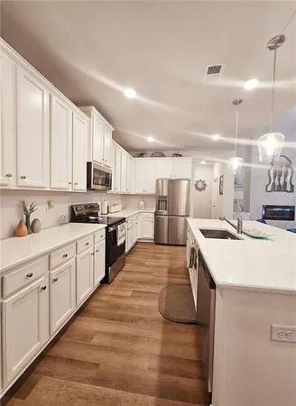 a large kitchen with kitchen island a sink a stove and cabinets