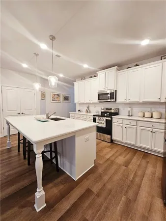 a kitchen with a lot of white cabinets and a wooden floor