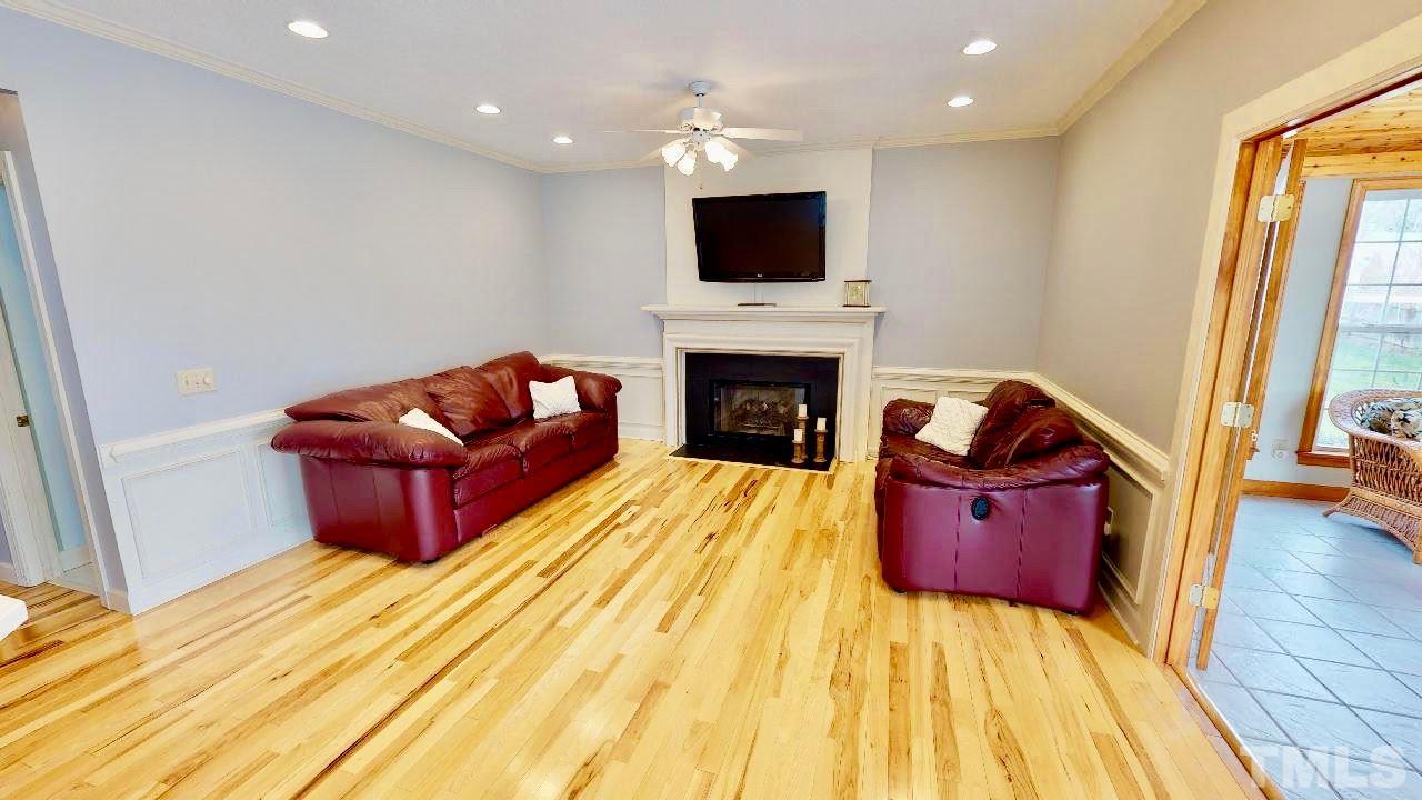 7504 Boscobel Way Raleigh, NC 27615 - Photo 12 of 25 a living room with furniture a flat screen tv and a fireplace