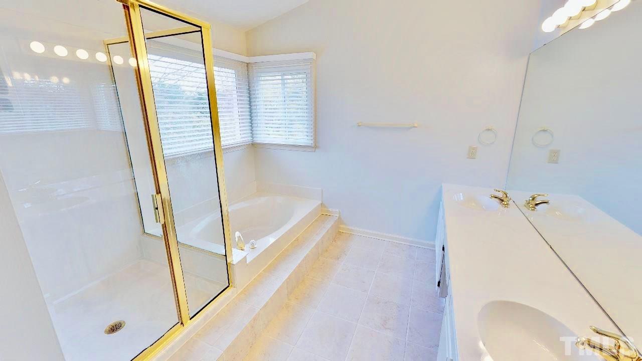 7504 Boscobel Way Raleigh, NC 27615 - Photo 18 of 25 a bathroom with a tub and a shower