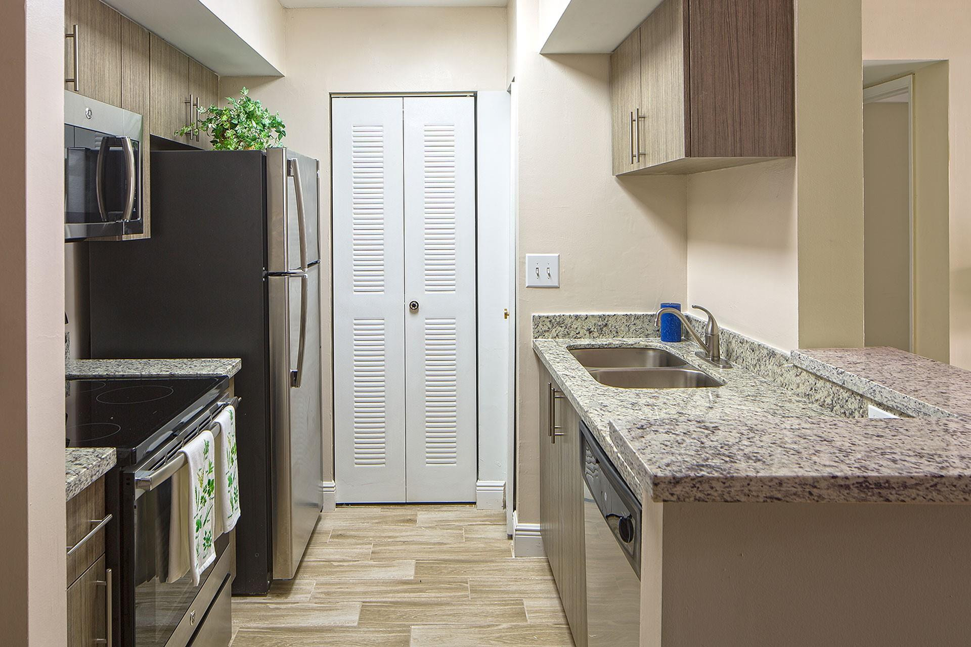 13901 122nd Avenue, Unit 4308 Miami, FL 33186 - Photo 4 of 8 a kitchen with stainless steel appliances granite countertop a refrigerator and a sink