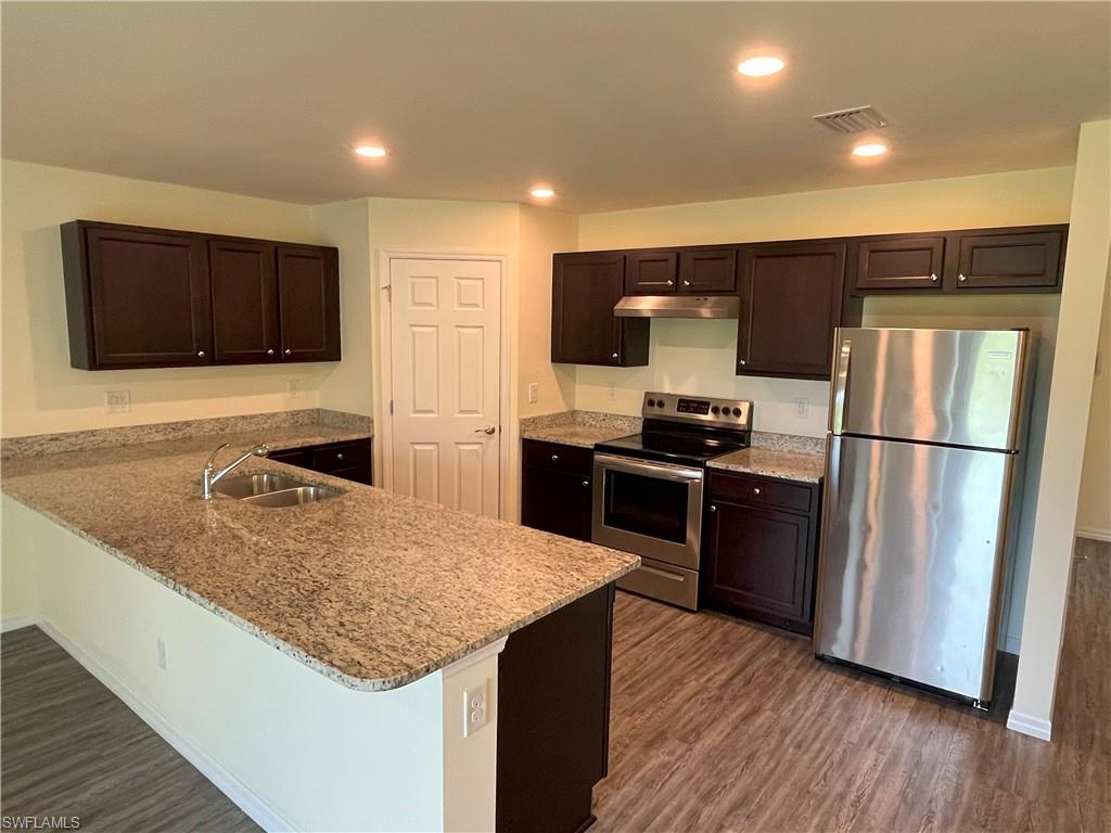 1187 Highlands Road Punta Gorda, FL 33983 - Photo 4 of 21 a kitchen with kitchen island a counter top space a sink and stainless steel appliances