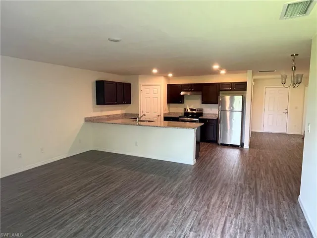 a view of kitchen with sink microwave and refrigerator