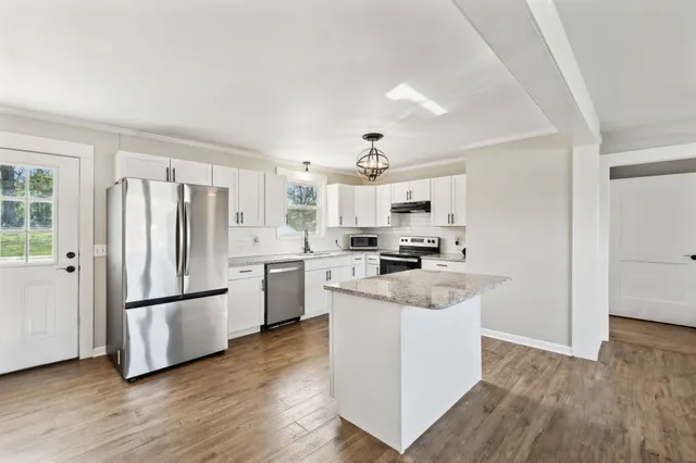 a kitchen with white cabinets and stainless steel appliances